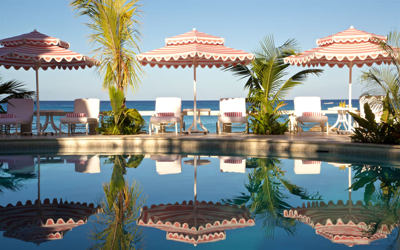 Luxury Barbados hotel poolside with striped umbrellas and ocean view