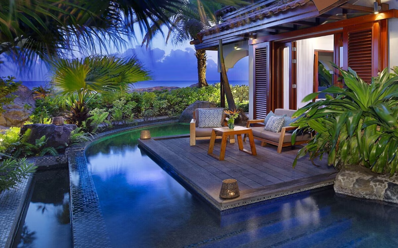 Romantic private villa at Baoase Luxury Resort Curaçao with plunge pool and tropical garden at dusk.